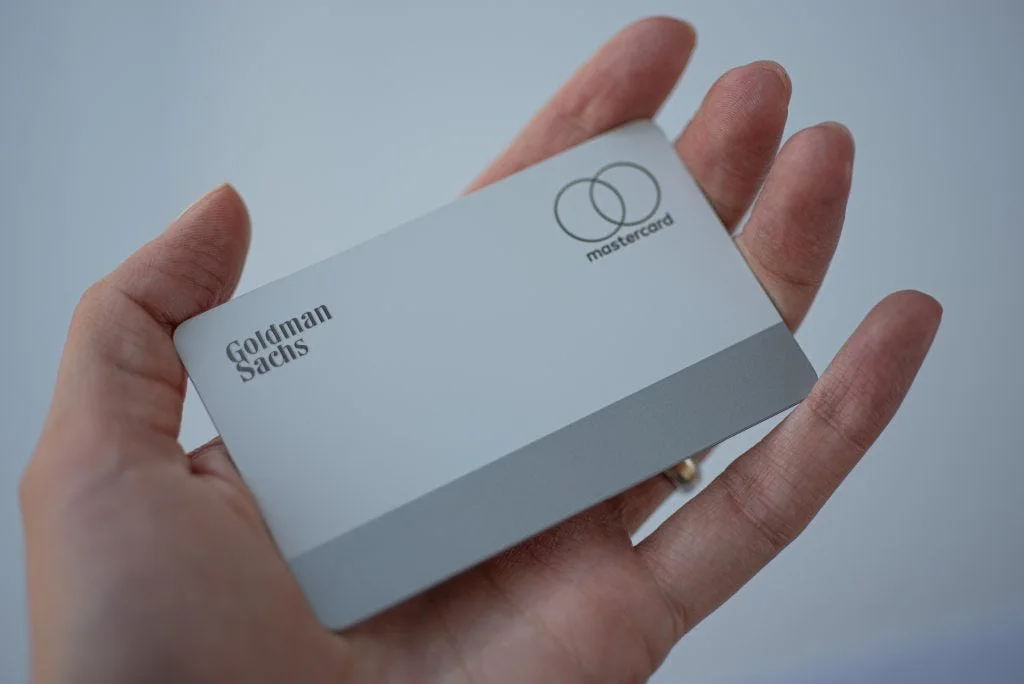 A white Goldman Sachs card held in an open hand
